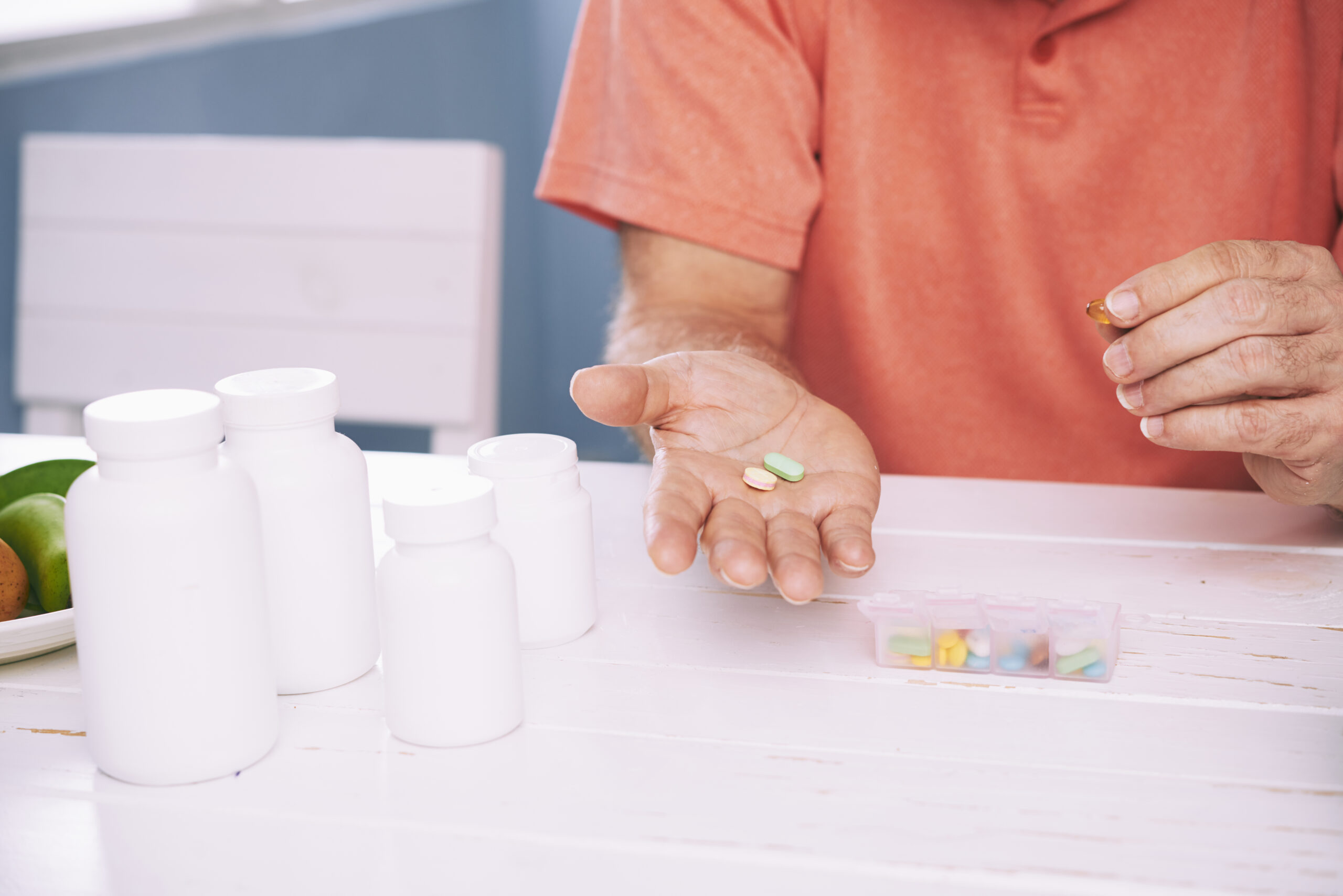 Closeup hands of senior man holding pills on his palm
